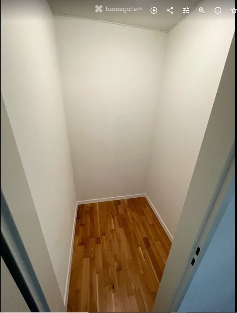 Completely empty room with bare white walls and wooden floor. No furniture or equipment.