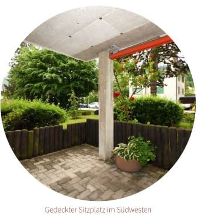 Patio area with a wooden fence, potted plant, and a covered seating area with a white roof and red awning.