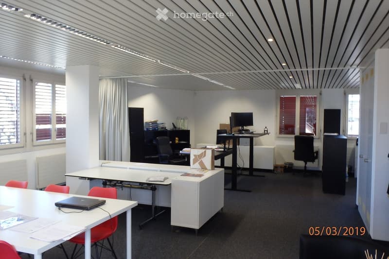 Modern office, white desk, office chairs, black office cabinets, shelves, computer monitors, radiators, windows, open window with curtains, date stamp