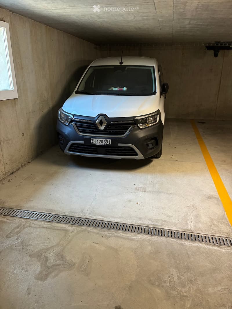 {"visible_features": ["Garage"], "type": "Garage", "objects": [], "description": "Underground garage with a single white van parked inside, concrete walls and floor, yellow parking lines, and a small window on the left side.", "localized_descriptions": {"