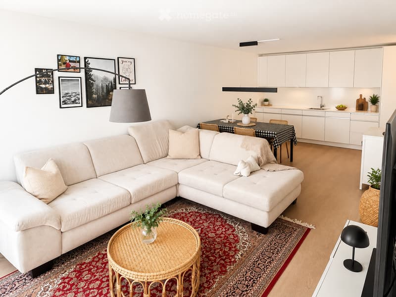 Modern living room with a white sectional sofa, coffee table, dining area with a table and chairs, and a fitted kitchen with white cabinets and a sink.
