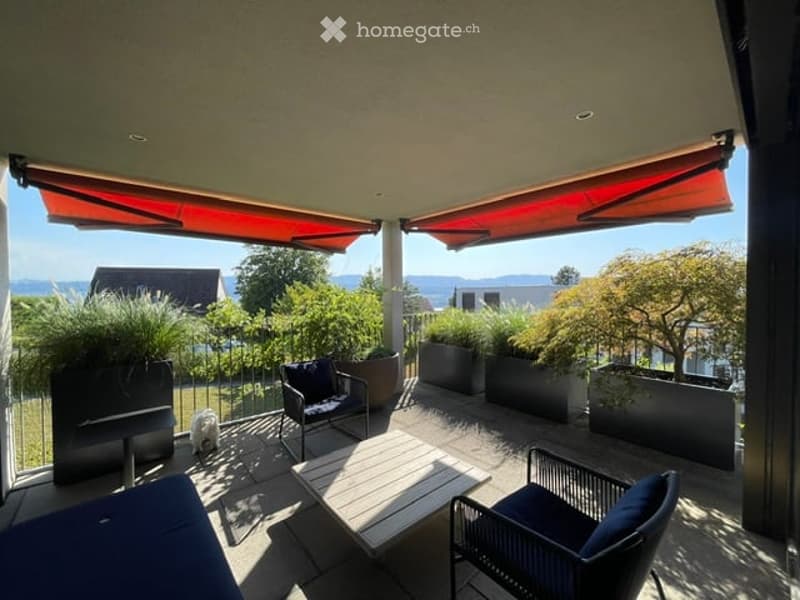 Balcony with outdoor furniture, potted plants, and a scenic view of the surrounding area.