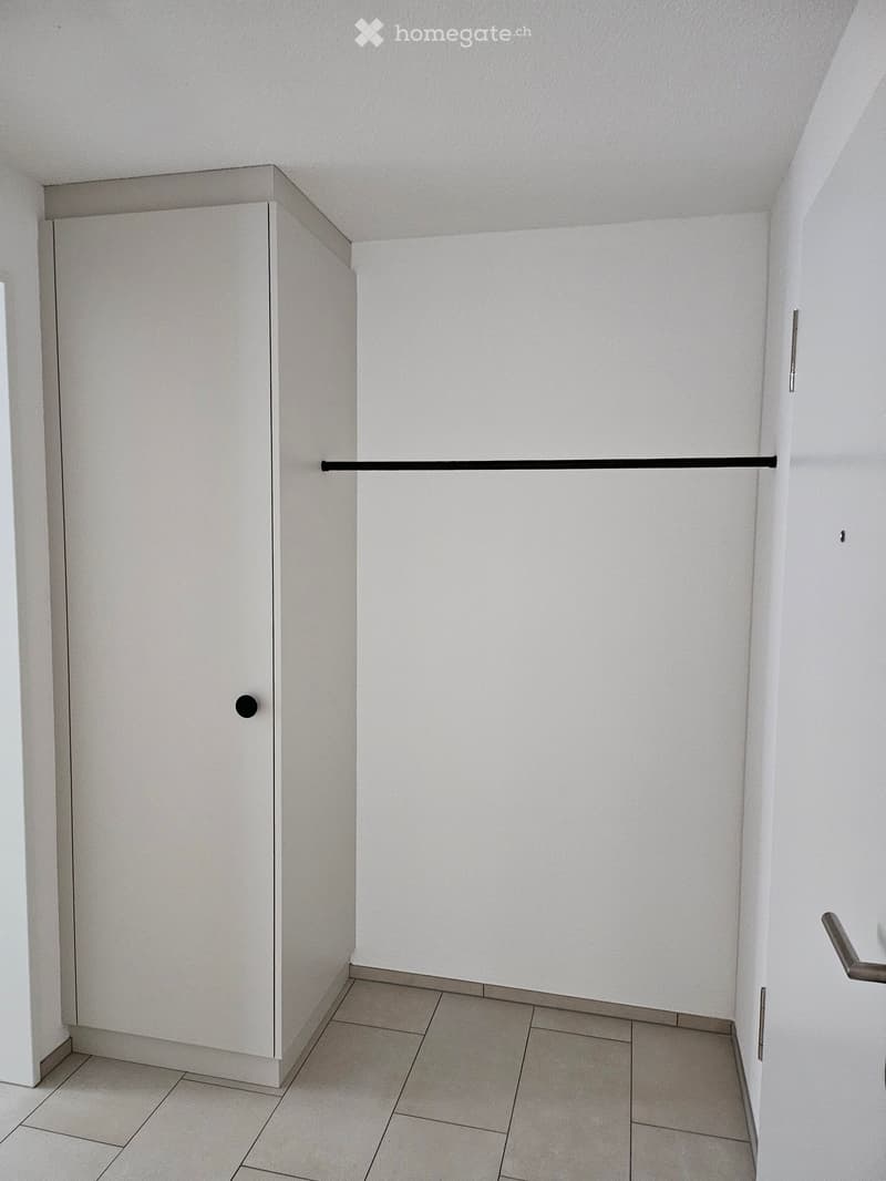 Empty room with white walls, tiled floor, and a built-in closet with a sliding door.