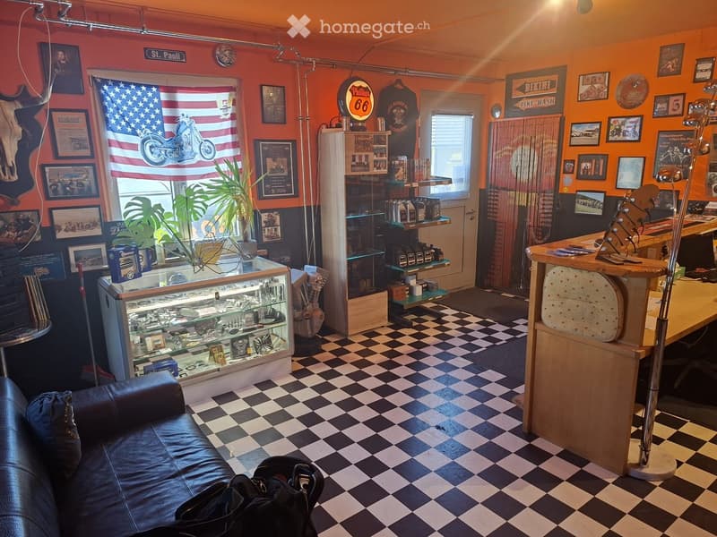 A vibrant, themed room with orange walls, checkered flooring, and a mix of furniture and decor including a leather sofa, a counter, shelves, framed pictures, and a plant. The room features a display case with various items and a refrigerator.