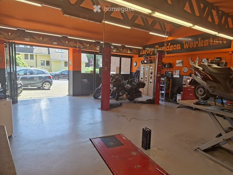 Garage with orange walls, multiple motorcycles, a car, and various tools and equipment.