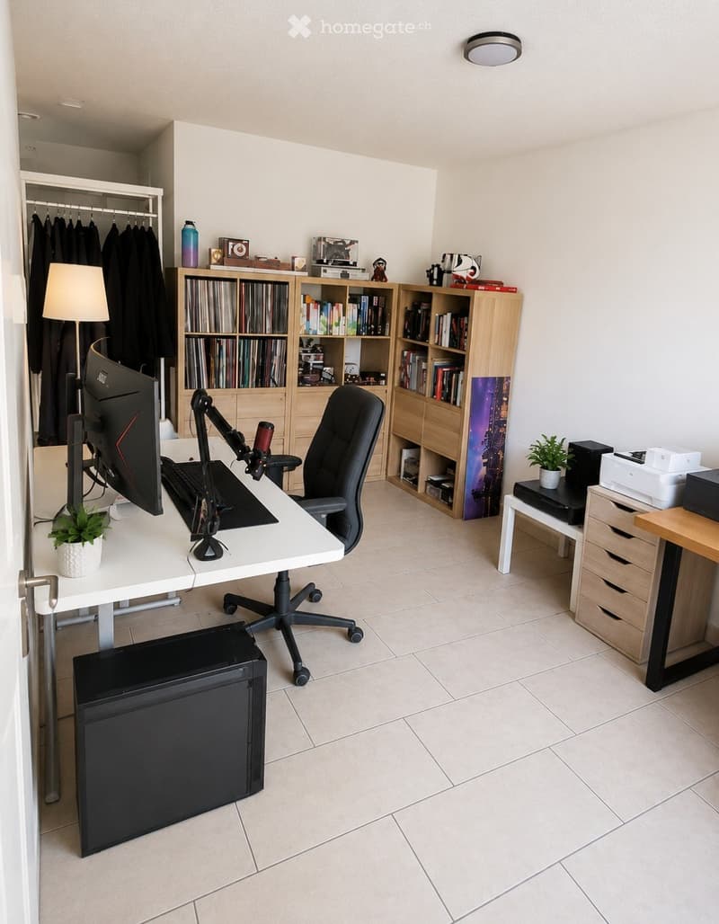A modern, well-organized home office with a white desk, ergonomic chair, large screen, keyboard, bookshelf filled with books and decorative items, a small potted plant, and a lamp. The room features tiled flooring and a built-in closet with hanging clothe