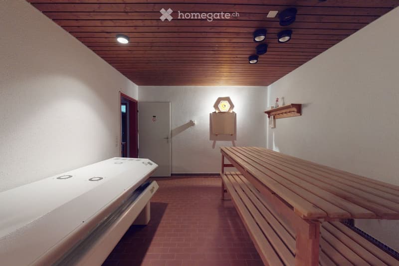 Sauna room with wooden bench, white sauna bench, small shelf, and mirror on the wall.