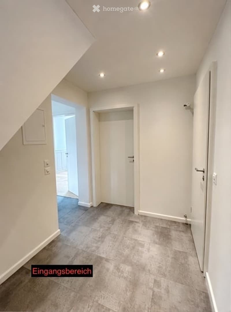 Empty entrance area with tiled floor, white walls, and built-in storage cabinet. No furniture or equipment present.