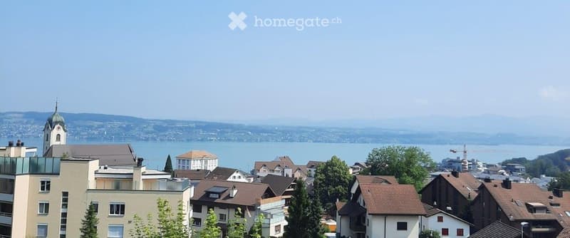 a few buildings in a hillside town with lake view