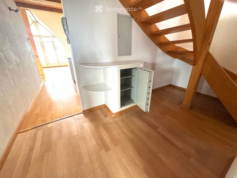 wooden floor, white wall, open safe, wooden stairs, telephone