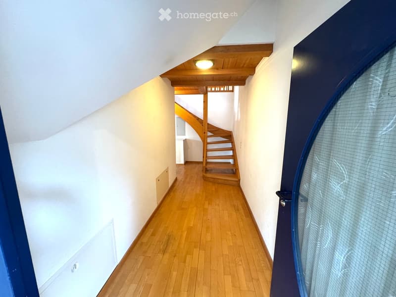 wooden floor, white walls, wooden staircase, blue door, light on the ceiling