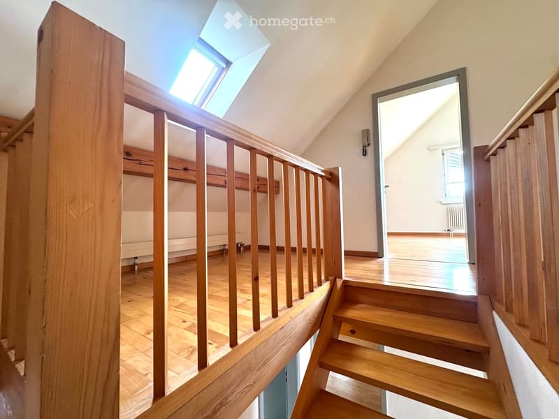wooden stairs, wooden railing, wooden floor, white walls, attic window