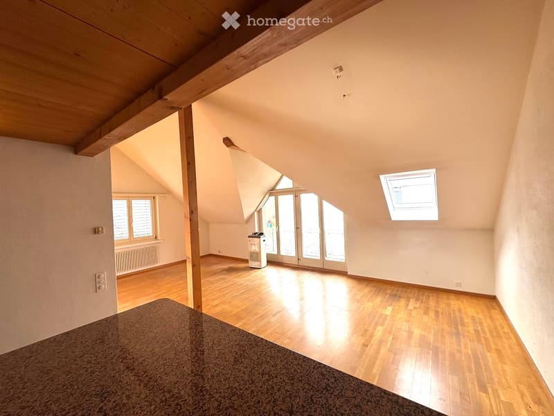 empty room, wooden floor, white walls, wooden beams, windows, sliding glass doors, small countertop