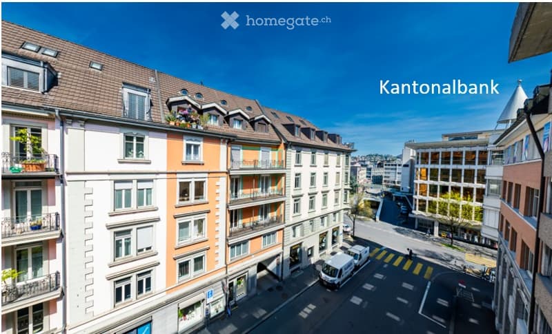 A multi-story residential building with colorful facades, multiple windows, balconies, and a clear view of the street and surrounding urban area.