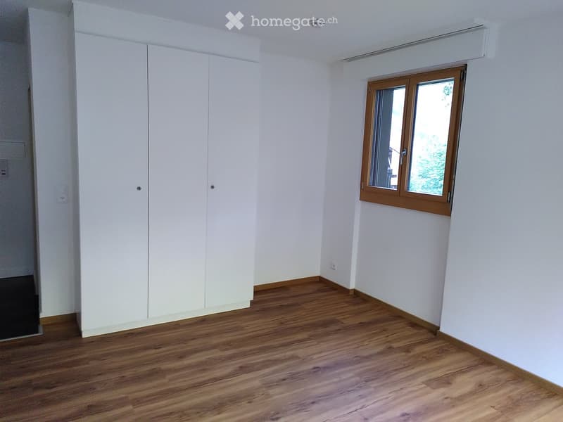 Empty room with white walls, wooden flooring, and a window with wooden frame. No furniture or equipment present.