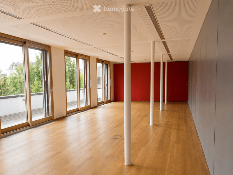 Empty hallway with wooden flooring, white walls, large sliding glass doors, and red storage units.