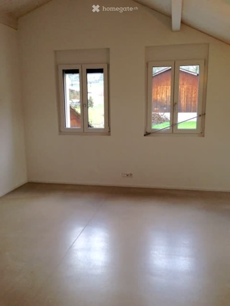 Empty room with white walls, tiled floor, and two windows with blinds. No furniture or equipment present.