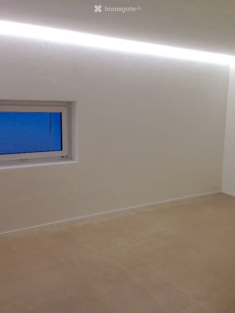 Empty room with beige carpet, white walls, and a single window with white frame.