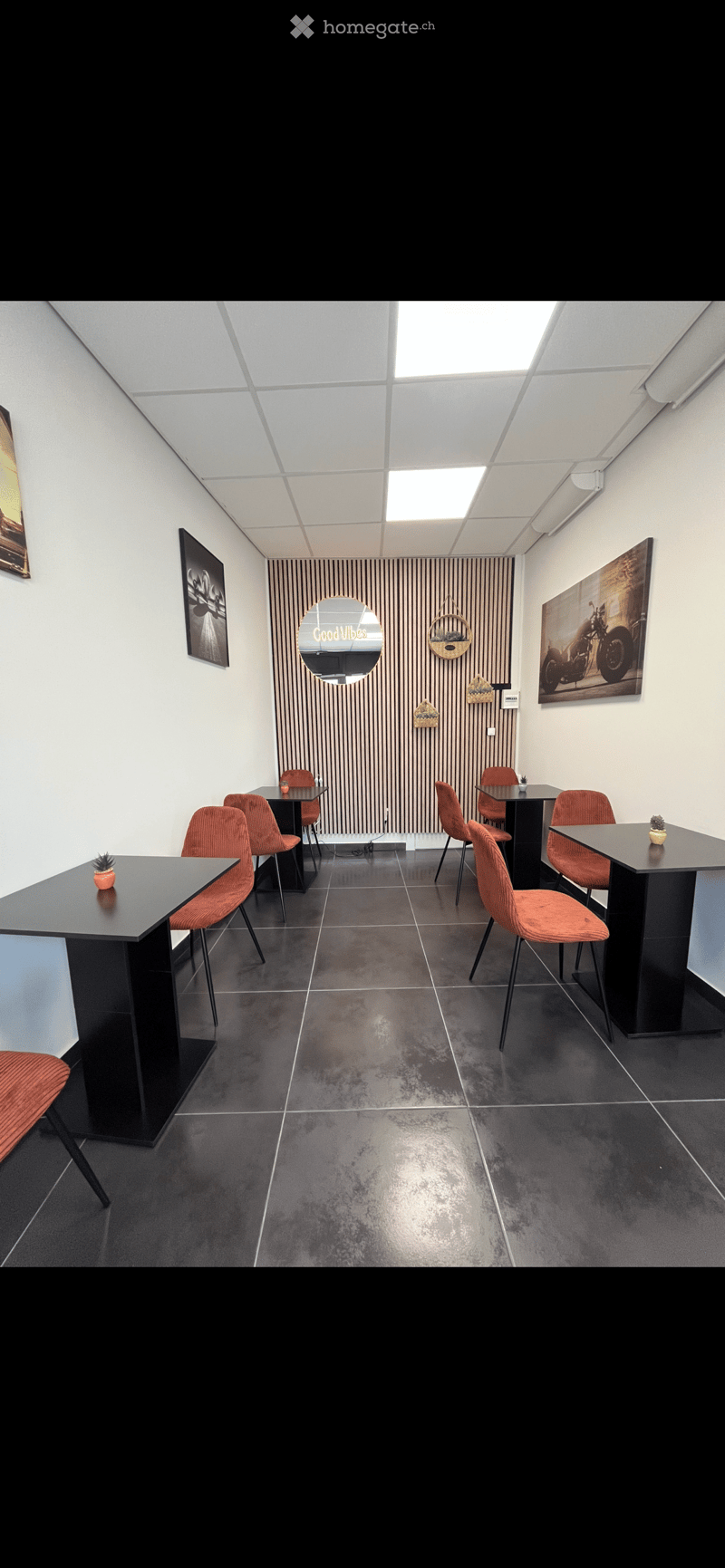 Modern minimalist interior, tables and chairs arranged for dining, picture frames on walls