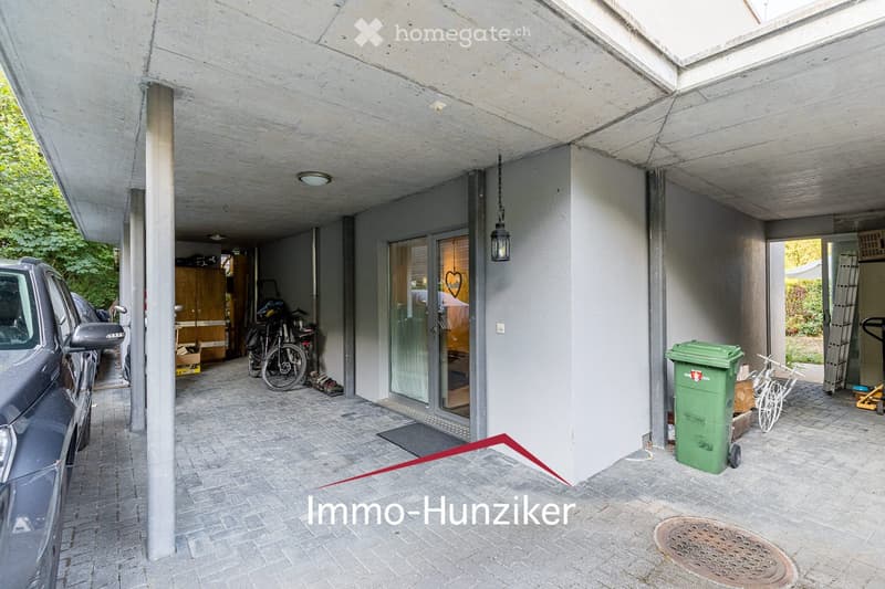 {"type": "Garage", "objects": [], "description": "Covered garage area with concrete ceiling, tiled floor, parked car, bicycles, and storage items.", "localized_descriptions": {"EN": "Covered garage area with concrete ceiling, tiled floor, parked car, bicy