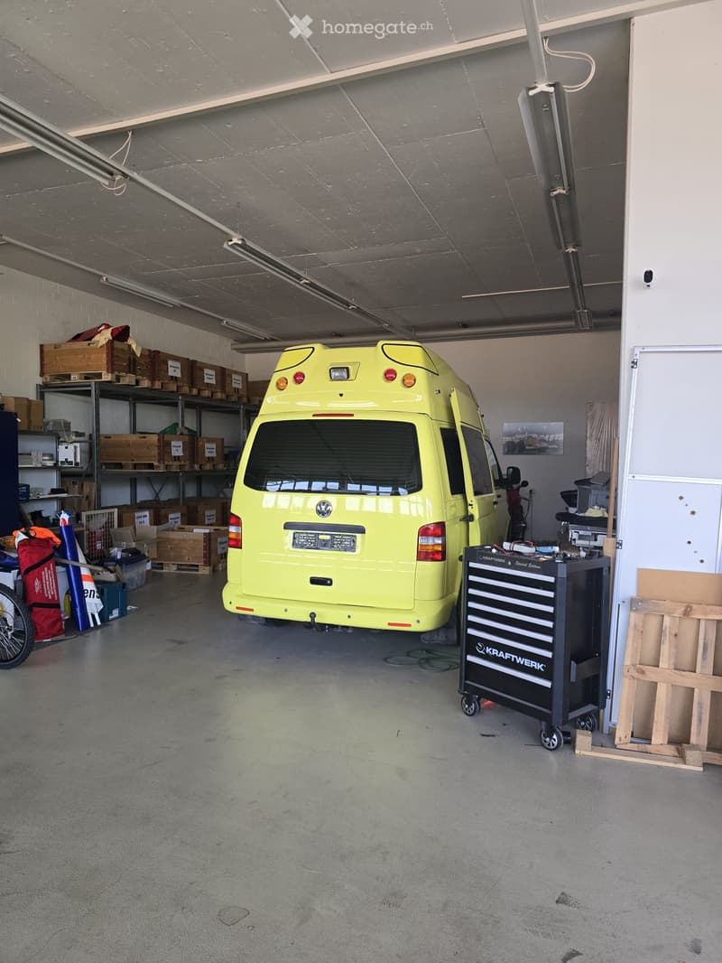 {"visible_features": ["Garage"], "type": "Garage", "objects": [], "description": "Garage with a yellow van, shelves with boxes, a tool chest, and various equipment.", "localized_descriptions": {"EN": "Garage with a yellow van, shelves with boxes, a tool c