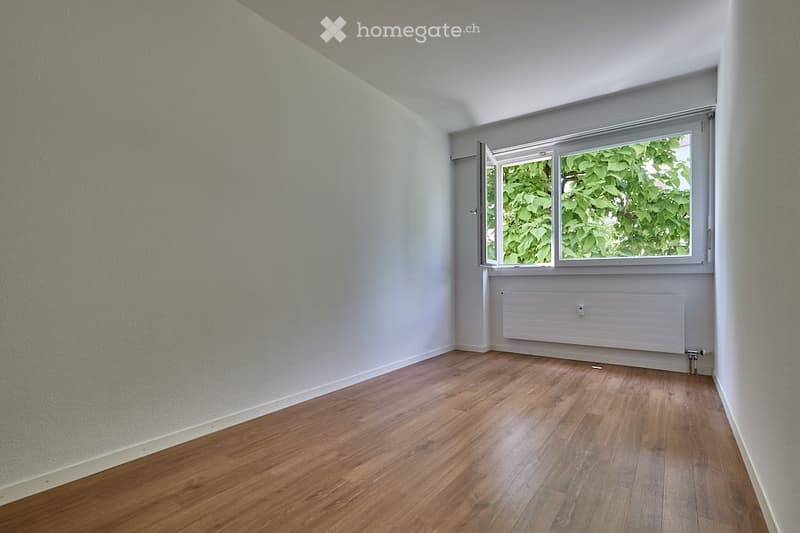 empty room, wooden floor, large window, white walls, radiator
