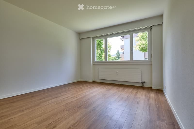 empty room, wooden floor, large window, white walls, built-in heater