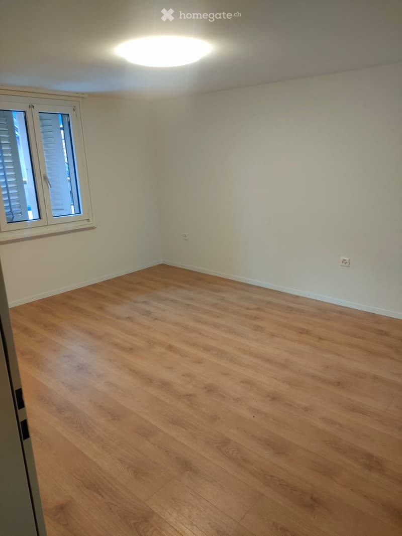 Empty room with hardwood floor, window, and two power outlets