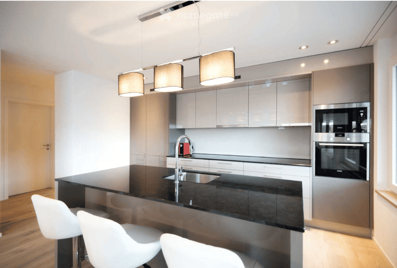 modern kitchen, black countertop, white chairs, silver cabinets, stainless steel microwave, dishwasher