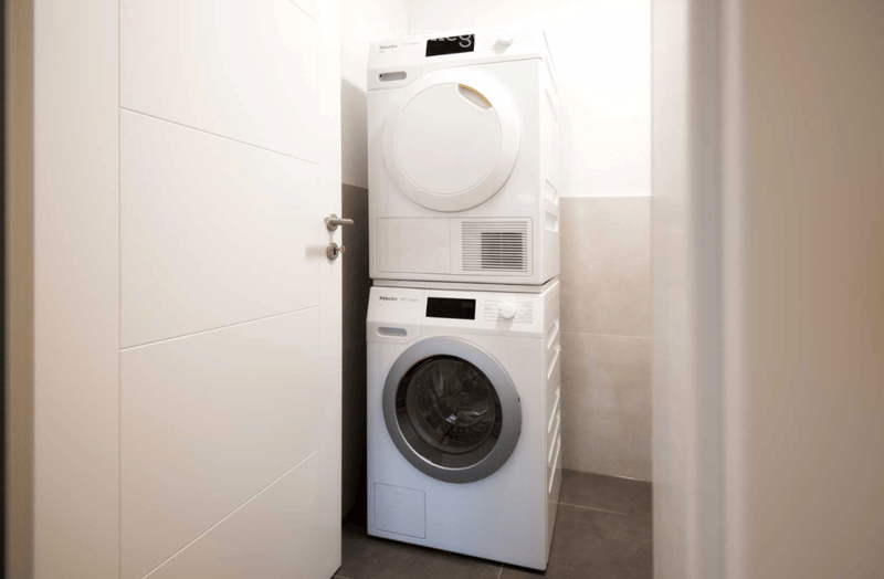 white washing machine, white dryer, modern, clean, tiled floor, metal door