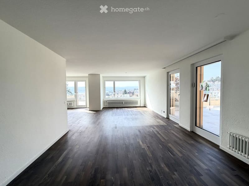 wooden floor, large windows, balcony with railing, sliding glass doors, white walls, heaters