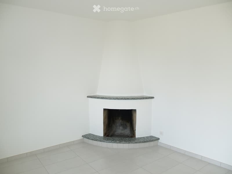 Empty room with white walls and tiled floor, featuring a built-in fireplace with granite surrounds.