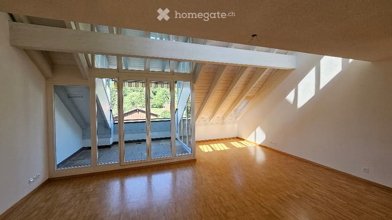 Completely empty room with wooden flooring, large glass sliding doors, and white walls.