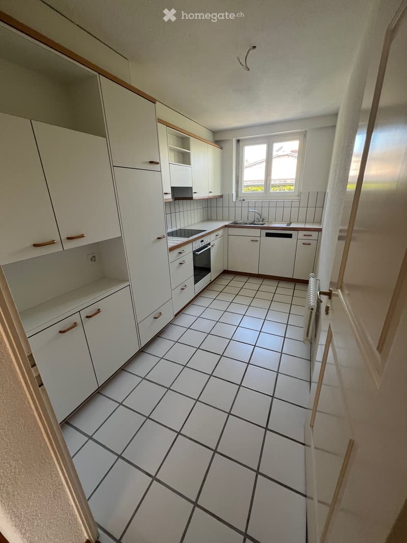 modern kitchen with white tiles, white cabinets, electric stove, oven, dishwasher, sink, window