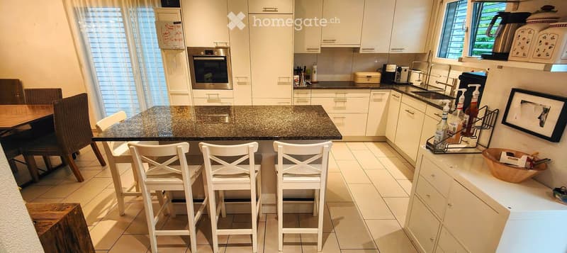 {"type": "Kitchen", "objects": ["kitchen island", "bar stools", "dining table", "dining chairs", "oven", "sink", "faucet", "cupboard", "cupboard", "cupboard", "cupboard", "cupboard", "cupboard", "cupboard", "cupboard", "cupboard", "cupboard", "cupboard",