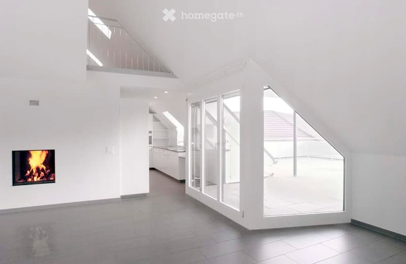 Modern, open-concept living space with a fireplace, kitchen area, and large glass doors leading to a balcony.