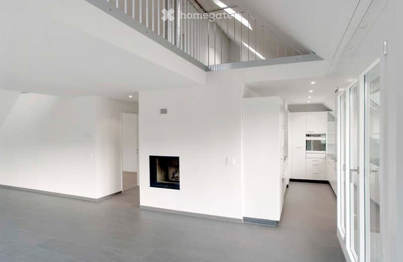 Open-plan space with a fireplace, white walls, grey tiled floor, and a modern staircase leading to an upper level.