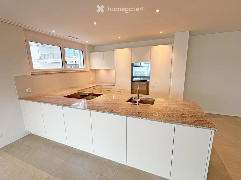 Modern kitchen with white cabinets, granite countertop, sink, and built-in oven.
