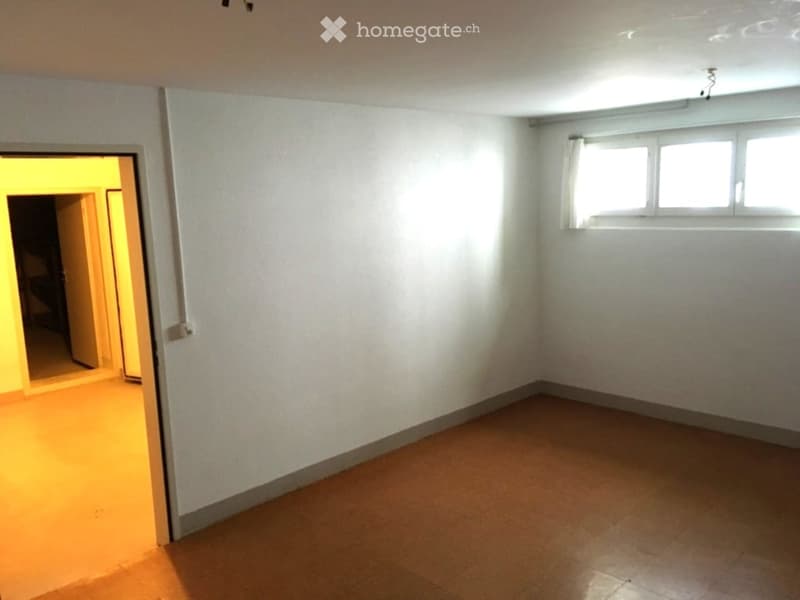 Empty room with white walls, tiled floor, and a window with white blinds. No furniture or equipment is present.