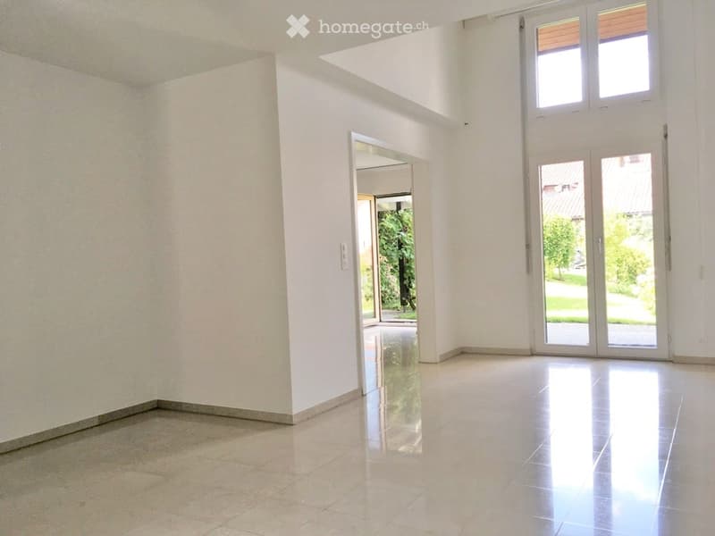 Empty room with white walls, large windows, and a polished tile floor. No furniture or equipment present.