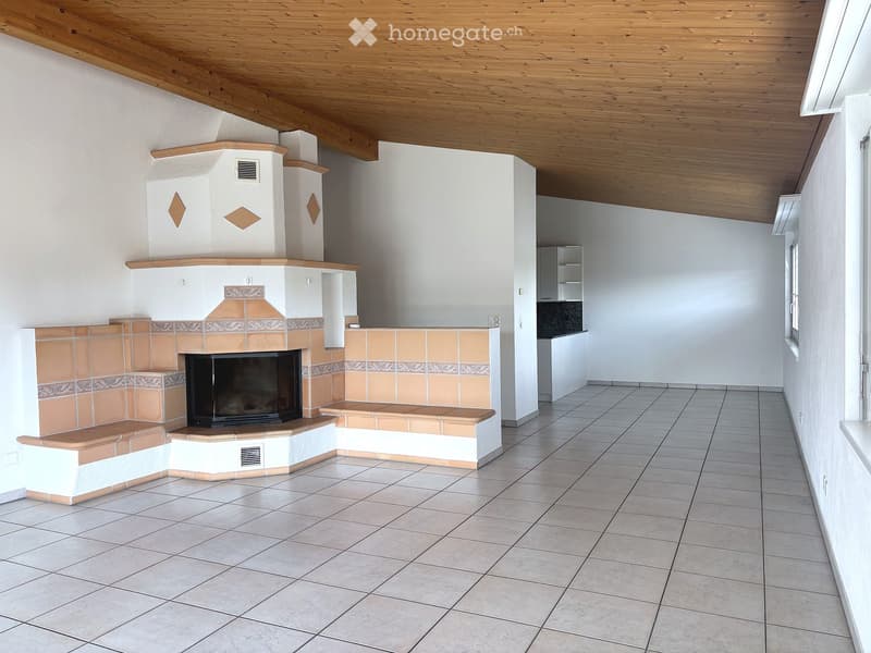 Bright room with a tiled fireplace, white walls, and a wooden ceiling.