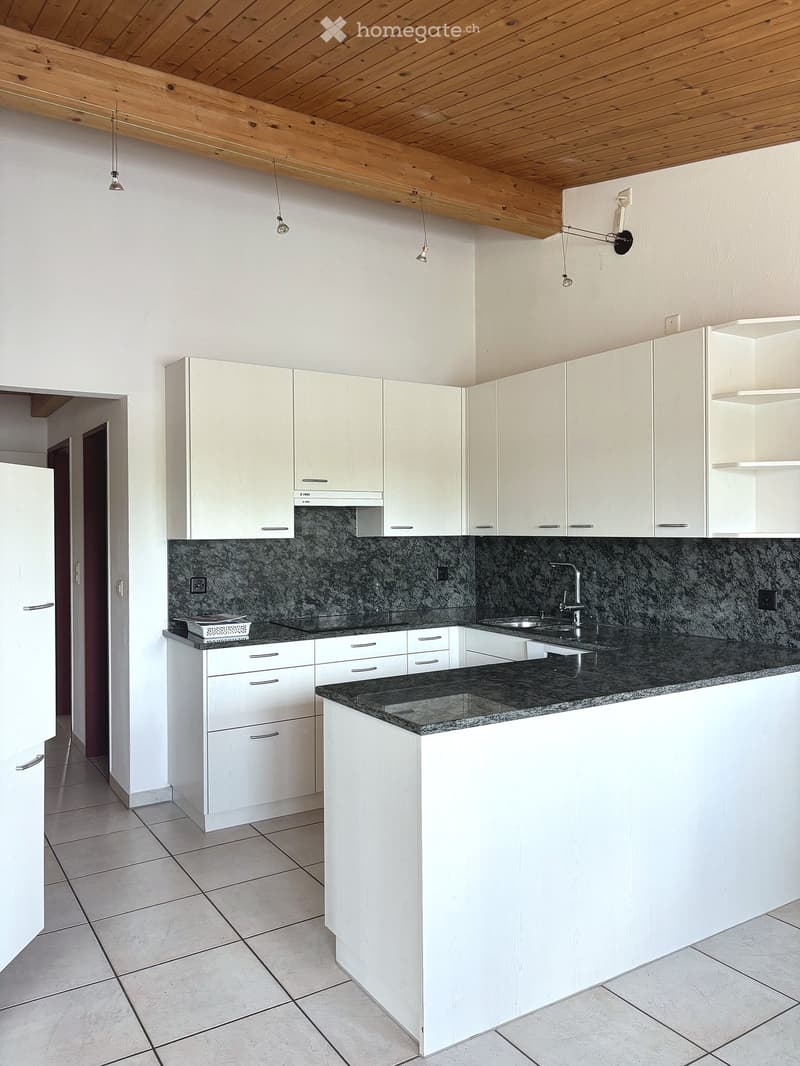 Modern kitchen with white cabinets, granite countertop, and stainless steel sink.