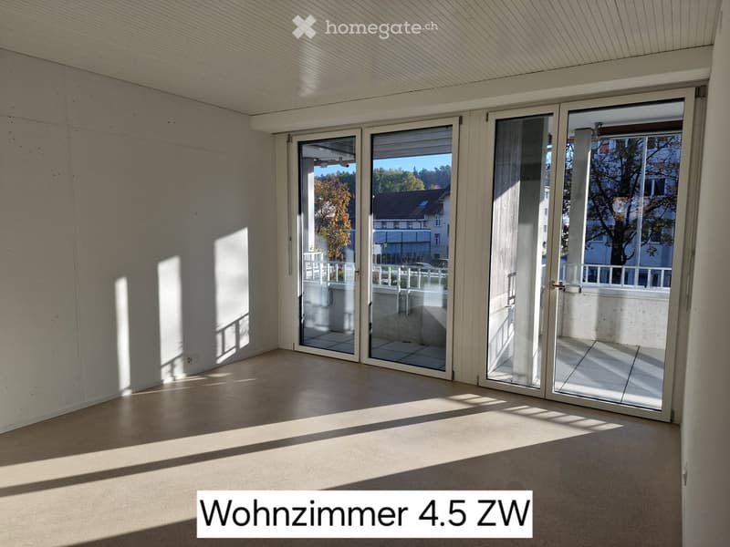Empty room with large sliding glass doors leading to a balcony, concrete walls, and a tiled floor.