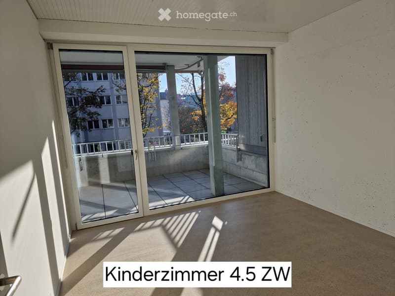 Empty room with smooth concrete floor and large sliding glass doors leading to a balcony area with tiled floor and metal railing.