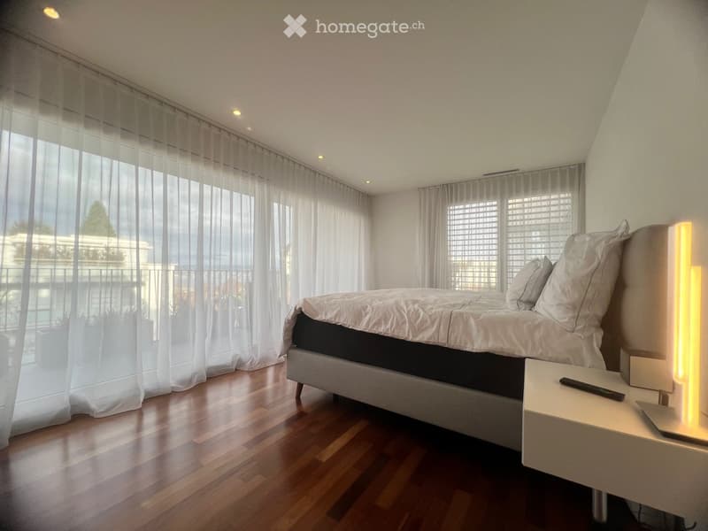 white walls, hardwood floors, king-size bed, pillows, nightstand, lamp, remote, long white curtains