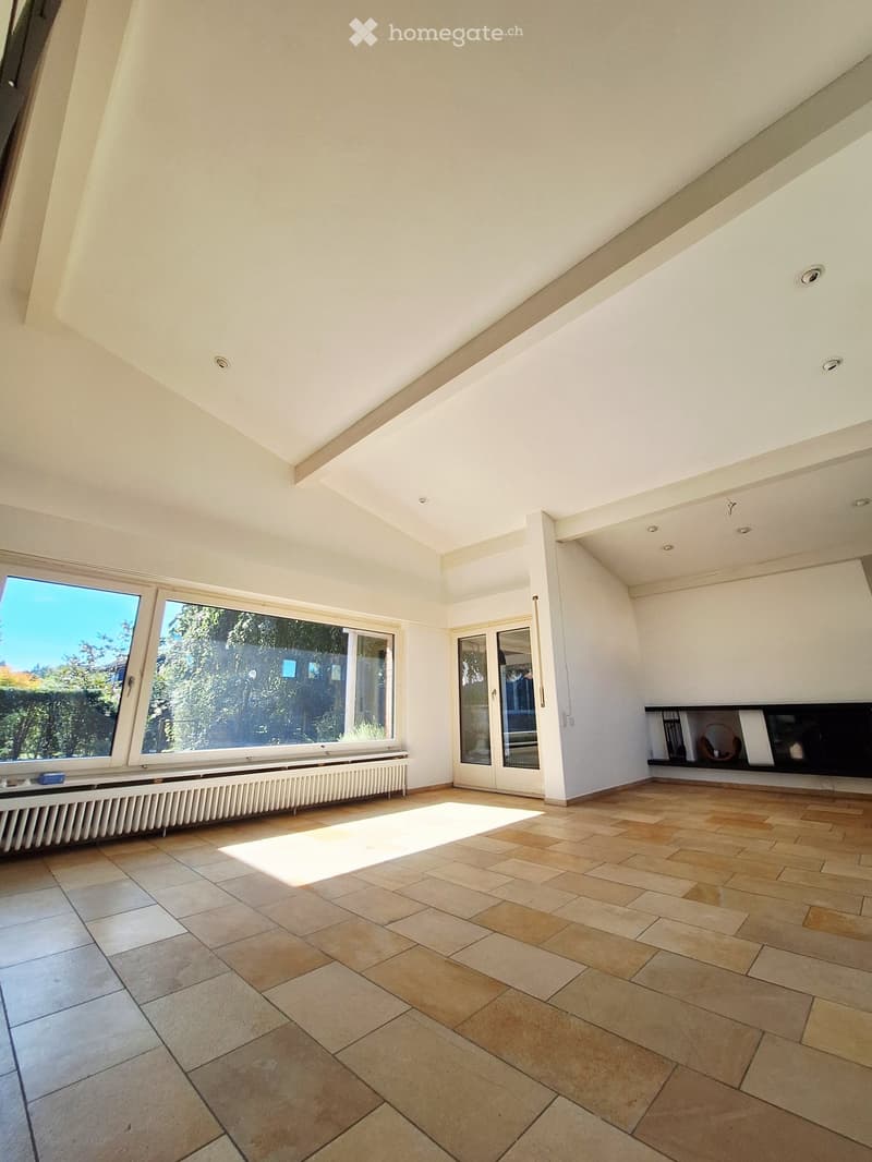 Empty room with tiled floor, large windows, and a built-in shelf unit.