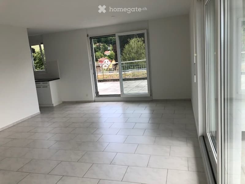 Empty room with large sliding glass doors leading to a balcony, tiled floor, white walls, and natural light.