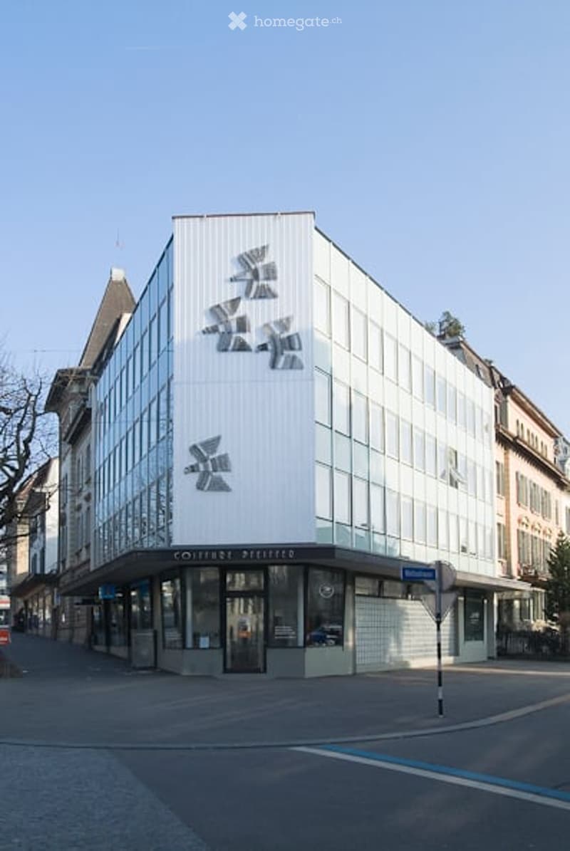 modern white office building with glass windows and geometric patterns
