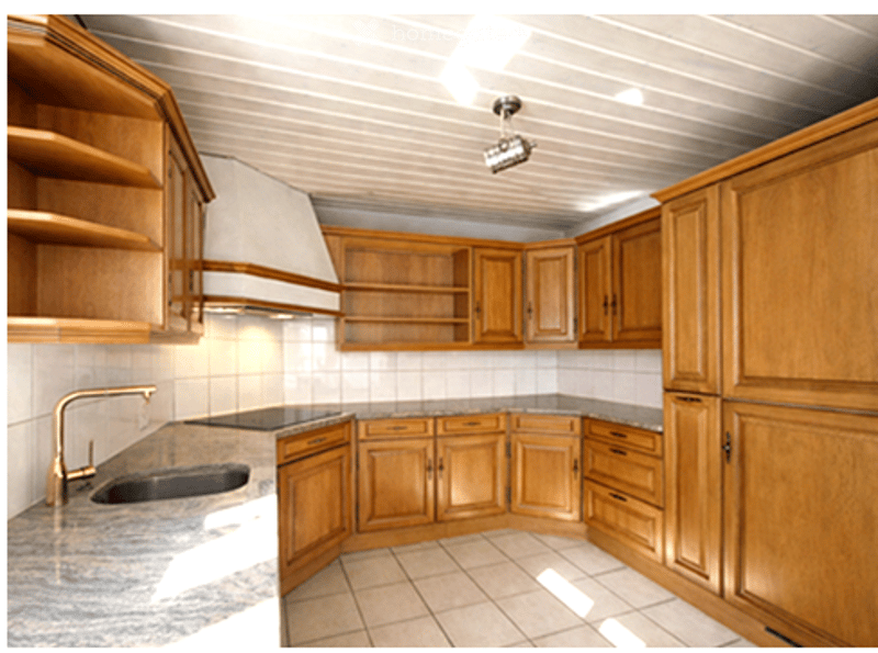 kitchen with wooden cabinets, granite countertop, sink, brass faucet, tiled floor, ceiling lamp