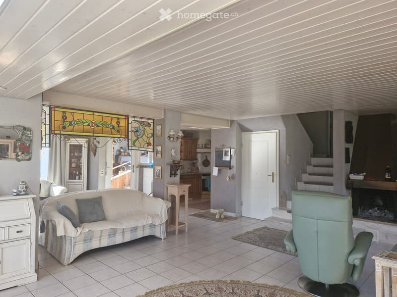white couch, green chair, fireplace, white tiles, white cabinet, wooden table, rug